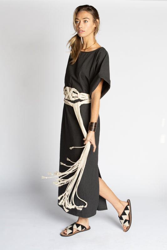 Model wearing long Midnight black Ghost Tropic sustainable organic cotton Didion dress with kimono sleeves round neck pockets and side slits with long wide natural macrame Amulet obi belt with tassels